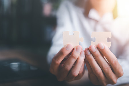 Businessman holding a puzzle piece to find a business solution,Connecting success and problem solution, from creativity,and strategic planning to develop the organization into the futureの写真素材