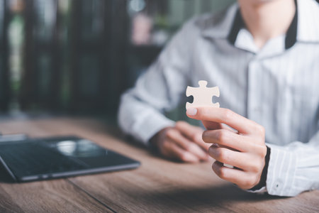 Businessman holding a puzzle piece to find a business solution,Connecting success and problem solution, from creativity,and strategic planning to develop the organization into the futureの写真素材