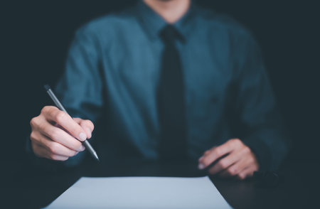 Businessman holding pen at desk, business document management concept and agreement,signing a business contract approval of contract documents confirmation or warranty certificate,employment ideaの写真素材