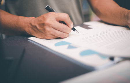 Business owner checking documents and reports and agreements To consider the approval of the business contract, before signing the signature, employment idea, project review, work from home.の写真素材