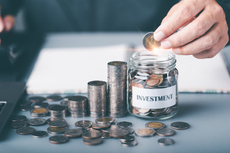 A young man put a coin in a glass jar,Finance and investment concepts, growth from profits and...