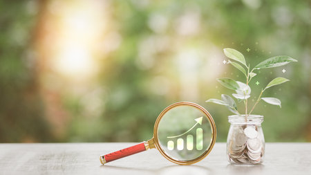 financial growth and investment ideas sustainable income and profit planning retirement preparation future fund management, magnifying glass Coin jar and tree all lay on the tableの写真素材
