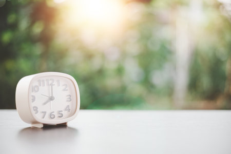 A white clock is placed on a wooden table, the concept of extinction of time, countdown, new beginning, appreciation of life, valuable use of time.の写真素材
