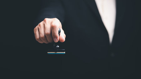 transaction management ideas and documents including negotiating legal entities and filling out legal forms or agreements,Young executives hold document stamps for business contractsの写真素材