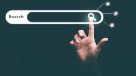 Man's hand pointing at search icon, technology concept researching keywords to find information from online websites, website link discovery and computer communication network, browsing web browser.の写真素材