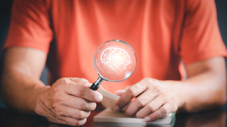 businessman holding a magnifying glass with a picture of a virtual brain and book To brainstorm ideas, imagination, inspiration, ideas for innovative technology, through ideas, education, creativity.の写真素材