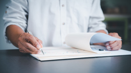 Management is reviewing and signing business contract documents. Transaction and document management concepts include negotiating legal entities and filling out legal forms or agreements.の写真素材
