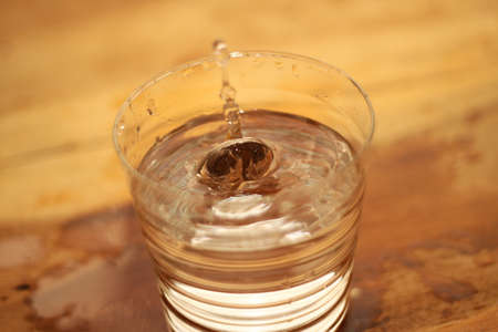 coin splashing water glass
