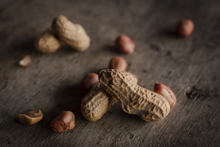 Peanuts placed on a wooden desk.