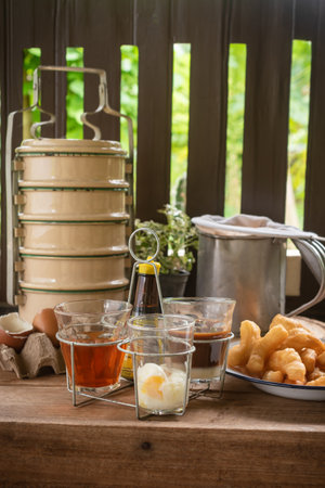 Rice porridge or pork congee for breakfast, boiled eggs, fried dough sticks, traditional coffee, soft-boiled eggsの写真素材