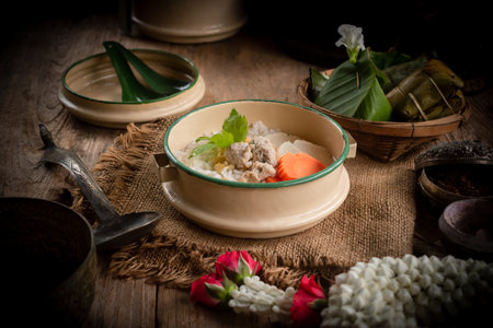 Pork congee, Thai desserts and jasmine flowers are placed on the dining table. Retro Thai style image.の写真素材
