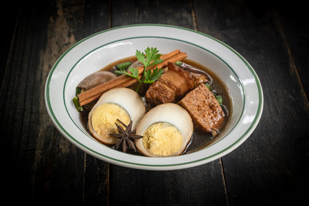 Brown boiled eggs with condiments in a bowl (braised eggs), rich broth, fragrant with herbs, a home-cooked Asian dish.の写真素材