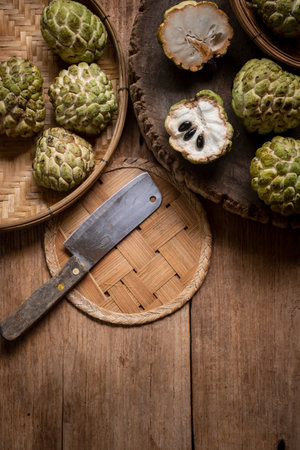 Custard apples on a wooden basket placed on an old wooden floor.