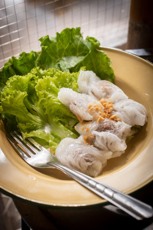 Thai Steamed Rice Dumplings with Lettuce and Butterfly Pea Flowers on Enamel Plateの写真素材