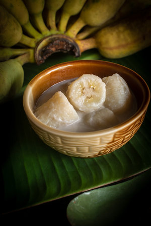 Kluay Buat Chi, a traditional Thai dessert made from ripe bananas cooked in rich coconut milk, served in a ceramic bowl with natural light still life style. Delicious Asian sweet food representing authentic Thai culture and tropical cuisine.の写真素材