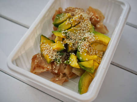 Fried Roti Topping with Avocado and White Sesame and Sweet milk Sauce in white plastic plate - Thai styleの写真素材