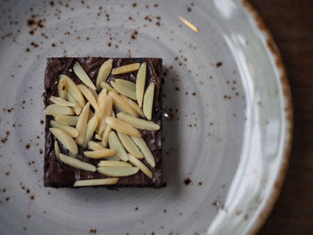 Variety of Brownies include Almond Macadamia Peanut and Chocolate Chip on the white dish and wood table from above viewの写真素材