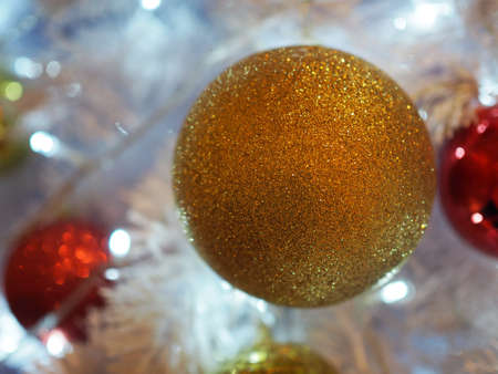 Gold ornament shiny ball on white Christmas tree. Have copy space for your text and use for blur background.の写真素材