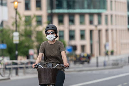 Young asian couple walking along the Embankment in London, England wearing maks in the Coronavirus COVID-19 pandemic lockdown enjoying the sun - 1のeditorial素材