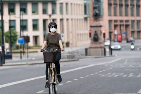 Couple walking along the Embankment in London, England wearing maks in the Coronavirus COVID-19 pandemic lockdowncrossing the road - 1のeditorial素材