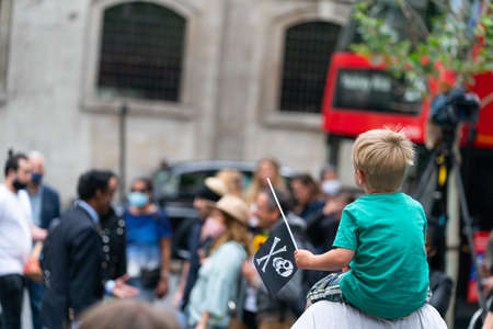 LONDON, ENGLAND - JULY 28, 2020: A young boy fan waving a Jolly Roger skull and crossbones flag outside the Royal Court of Justice in the Johnny Depp defamation libel Trial against The Sun Newspaper - 829のeditorial素材