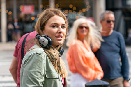 LONDON, ENGLAND - JULY 28, 2020: Beautiful female camerawoman wearing headphones filming for the...