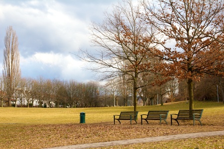 Three benches on the embankment of a lake in Freiburg, Germanyの写真素材