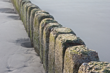 Detail shot of a stone groin at the beach of Sylt island, Germanyの写真素材