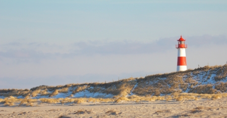 Beautiful sand dune scene with a lighthouse in the background