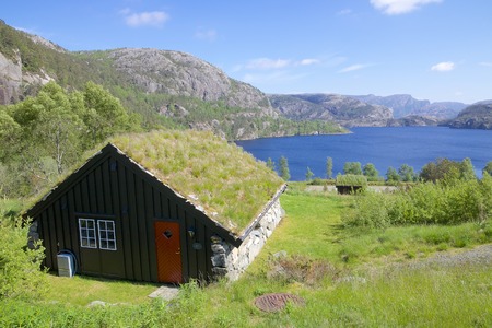 View over Norwegian Revsvatnet glacier lake and a traditional Norwegian cabin in the foregroundのeditorial素材