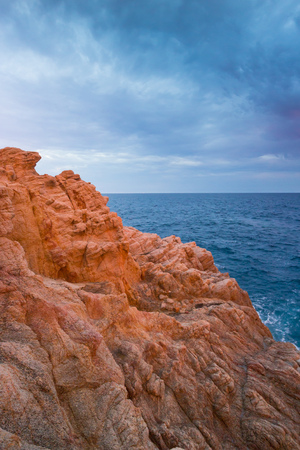 Rocky coast at the Spanish Costa Brava, Catalonia, in the warm evening lightの写真素材