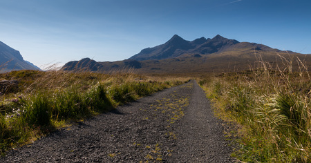 Gravel road leading towards the famous range of the Cuillin Hills on the Isle of Skye, Scotland
