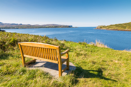 Wooden bench at the shore of Loch Harport, Isle of Skye, Scotlandの写真素材