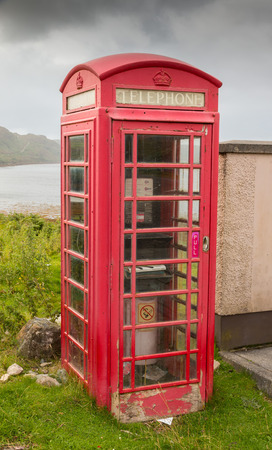 Typical red phone booth at the shore of Loch Inchard near Rhiconich village, Highlands, Scotland