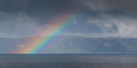 Rainbow in front of the Isle of Skye, Scotland, viewed from the mainland around Applecross villageの写真素材