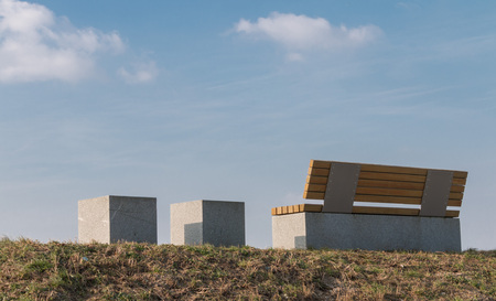 Modern bench and two marble seats on a dam along a river