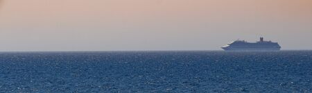 Huge cruise ship passing by in the distanceの写真素材