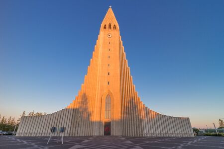 World famous Hallgrimskirkja, a lutheran cathedral in Reykjavik, shot in the warm light of a summer evening sunsetの写真素材