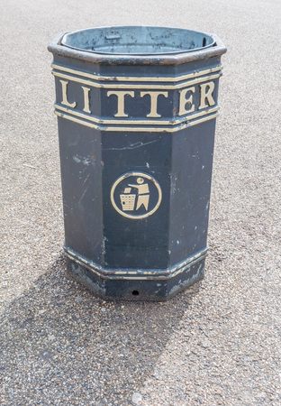 Closeup shot of a typical London trash can for litter, standing on a paved pathの写真素材