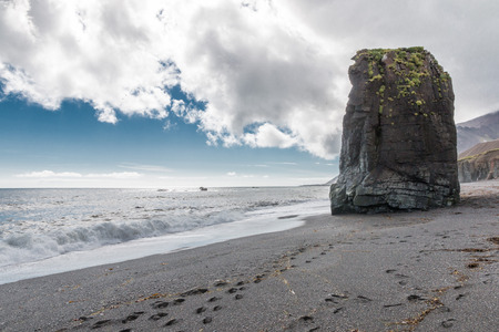 Volcanic black sand beach with harsh rocks in Austurland, eastern Icelandの写真素材