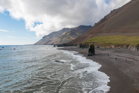 Volcanic black sand beach with harsh rocks in Austurland, eastern Iceland