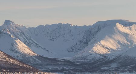 Epic Norwegian fjord and barren, snow covered mountains during sunset, far above the polar circle near Skjervoyの写真素材