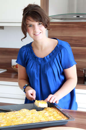 beautiful brunette woman bake cake in the kitchenの写真素材