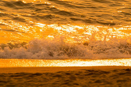 Colorful sunset on the tropical beach, orange sunset over sea,Sunlight hits the surface,sea wave on the beach with sunlight on sunset time at Pattaya beach.の写真素材