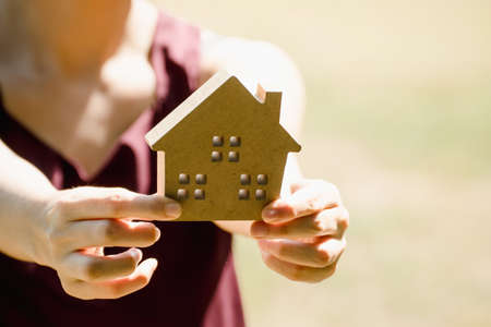 Hand holding a model of house.Hands of family holding model of house. toy house in hands.の写真素材