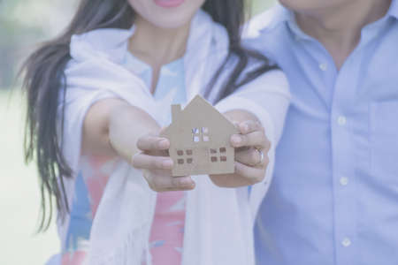 Hand holding a model of house.Hands of family holding model of house. toy house in hands.の写真素材