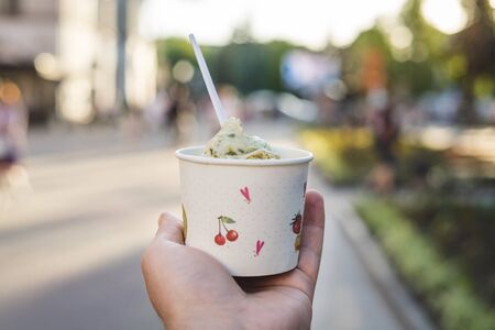Woman hand holds an pistachio ice cream. Summer dayの写真素材