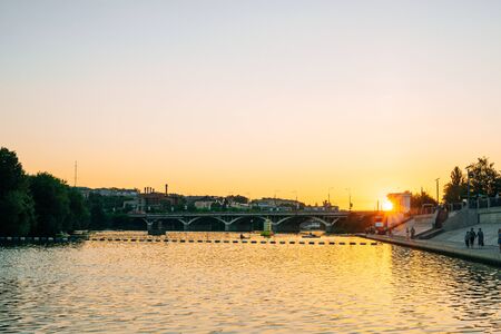 Bridge over river in summer warm evening. River on the background of the evening city. Panorama of the city from the river pierの写真素材