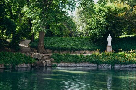 Sofia Park, Uman. National landscape park with lake and white statues. Orange flowers around a beautiful lake. Stone steps to the lake in the summer parkの写真素材