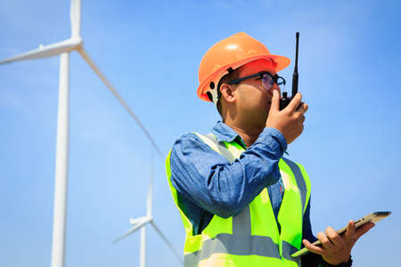 Engineers inspecting wind turbines produce electricity.